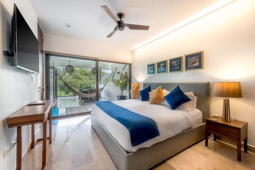 A guest bedroom as photographed, with white walls and blue bedding