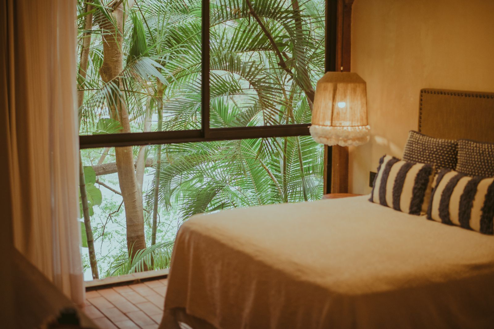 Made-up bedroom with a jungle view, ready for the first guest