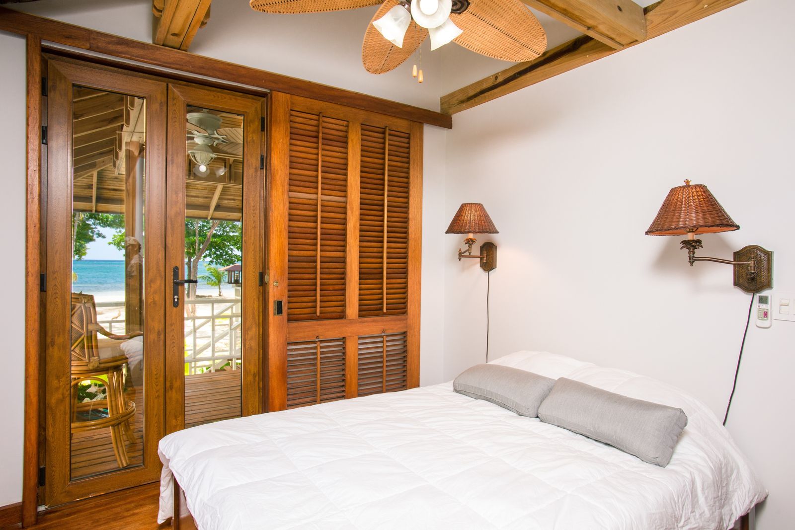 Bedroom with wood shutters opening to the sea