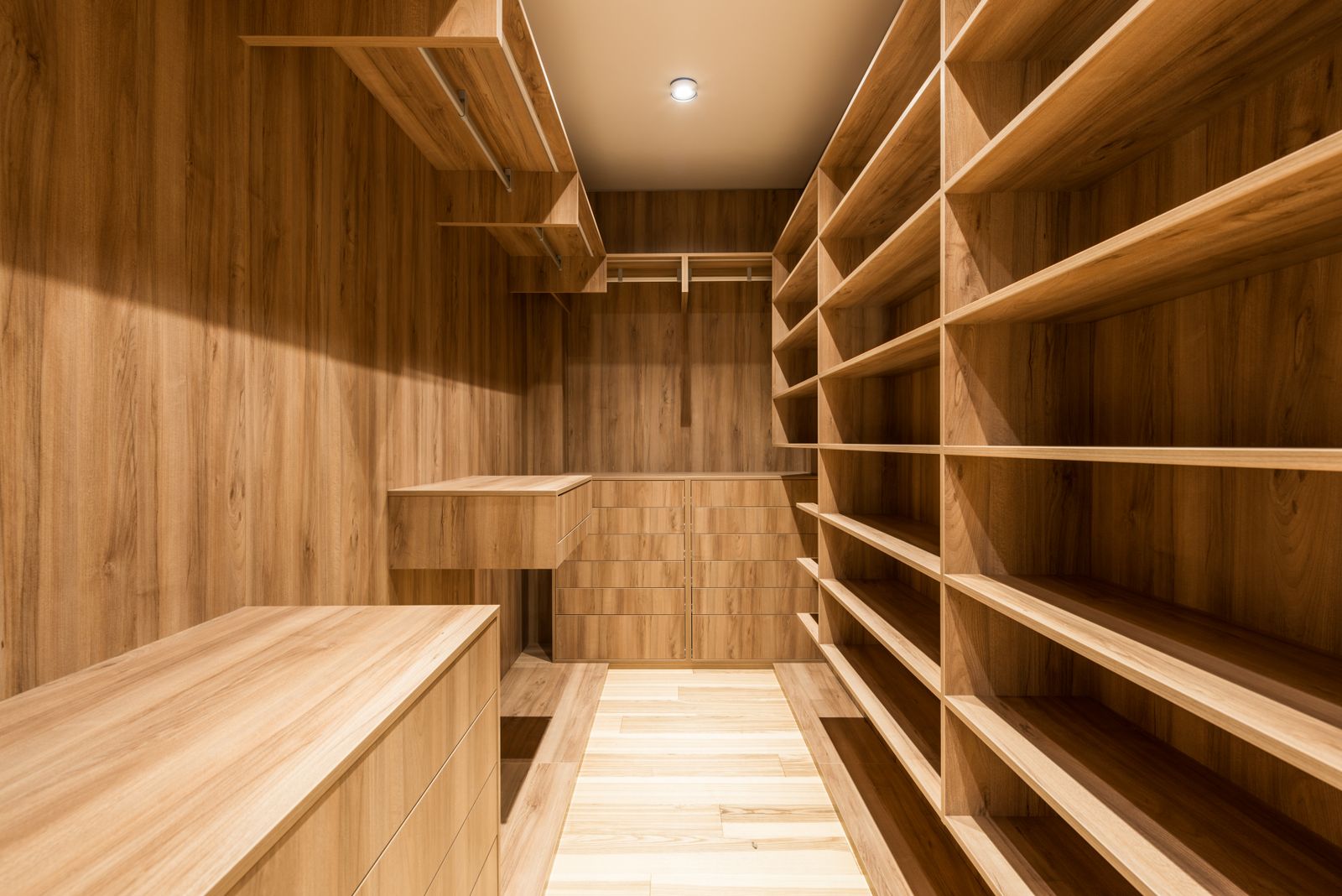 Oak walk-in closet with floor-to-ceiling built-in shelving made by the studio