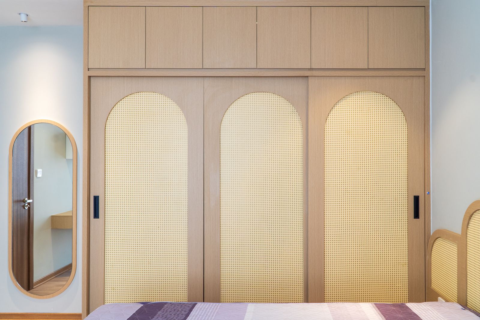Full-wall wardrobe with arched cane doors