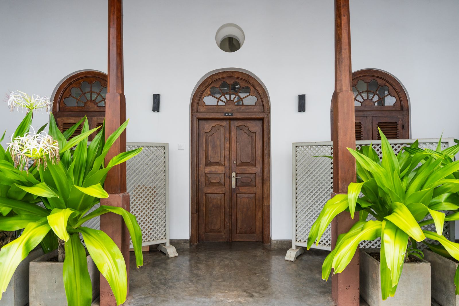 Arched wooden doors on a white terrace entry