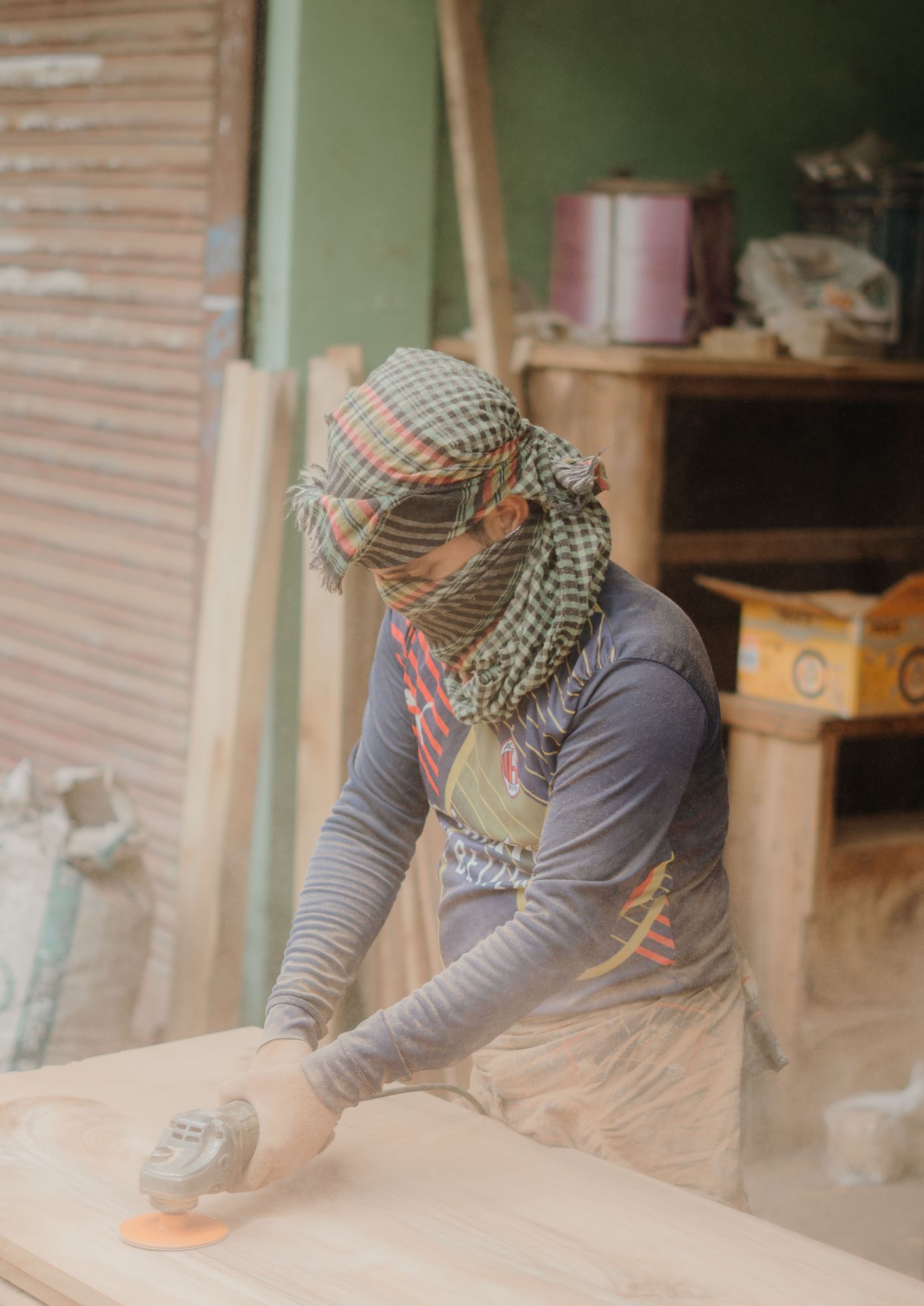 Woodworker sanding a solid-wood bed component