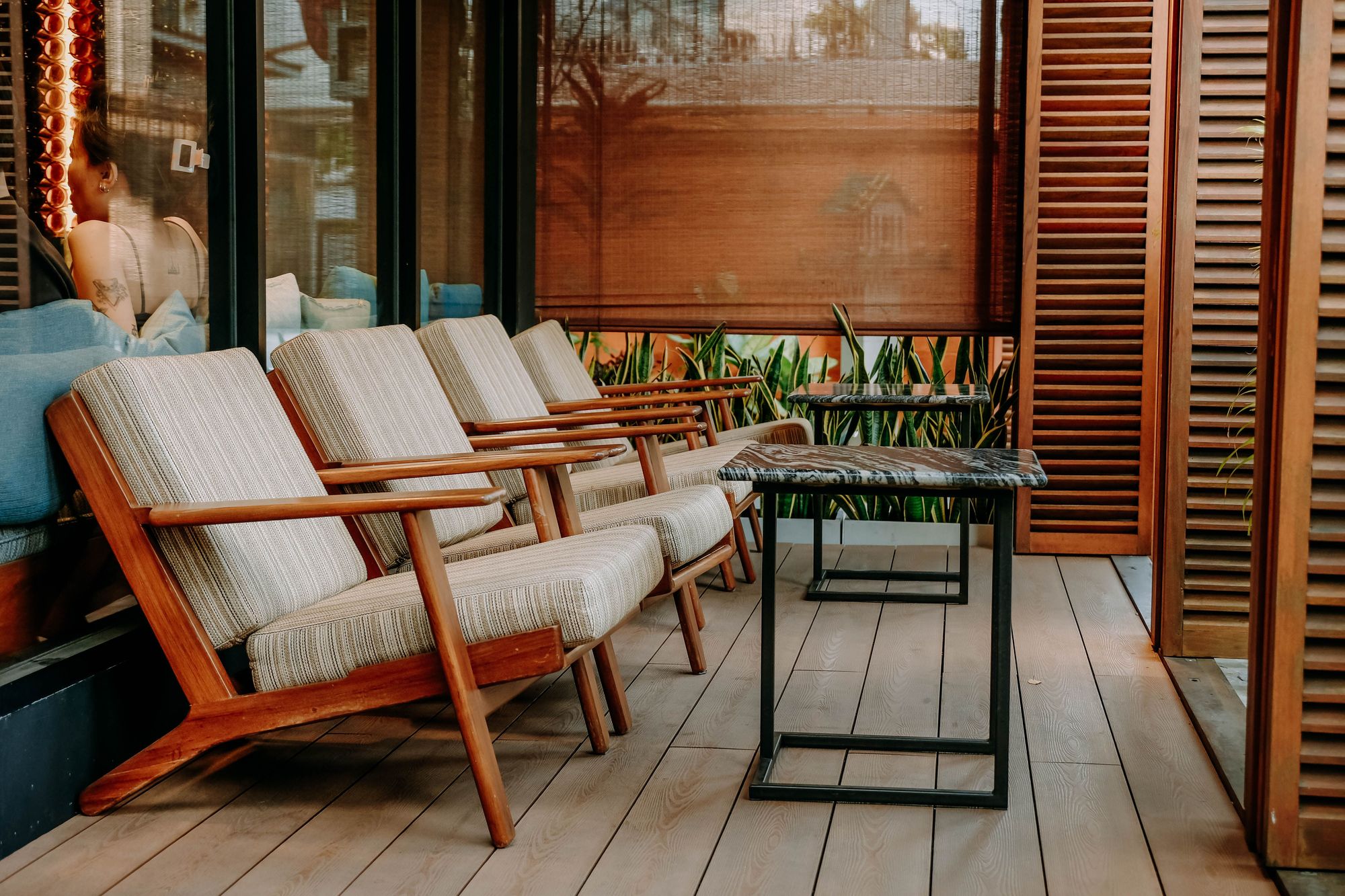 Row of teak lounge chairs on a covered deck