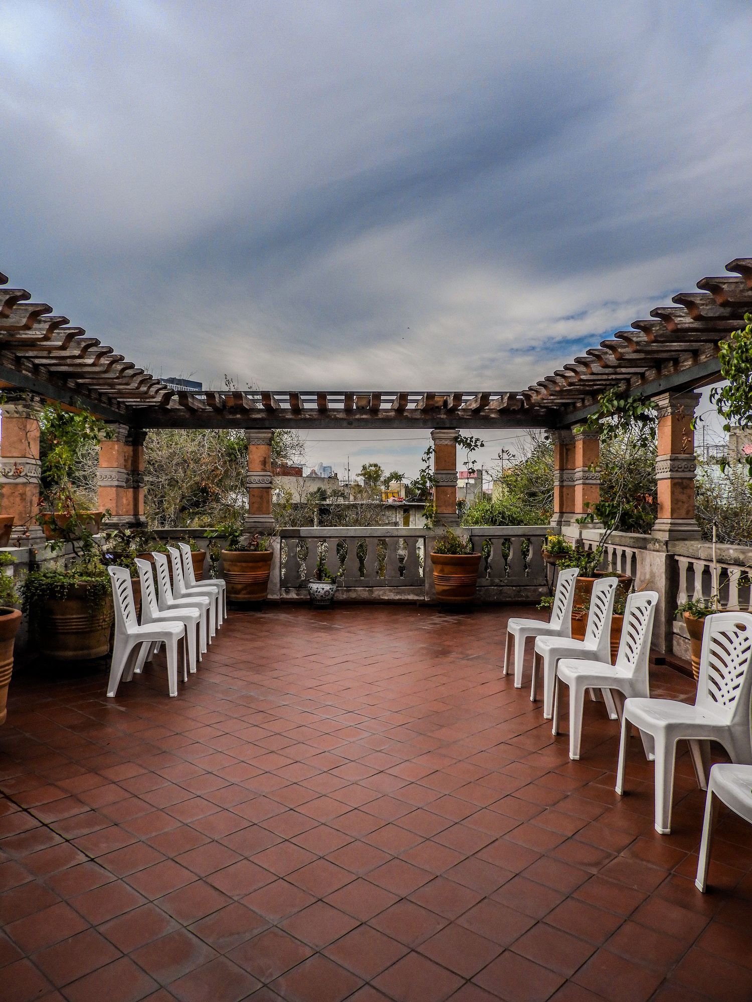 Covered terrace with a pergola and terracotta tile floor