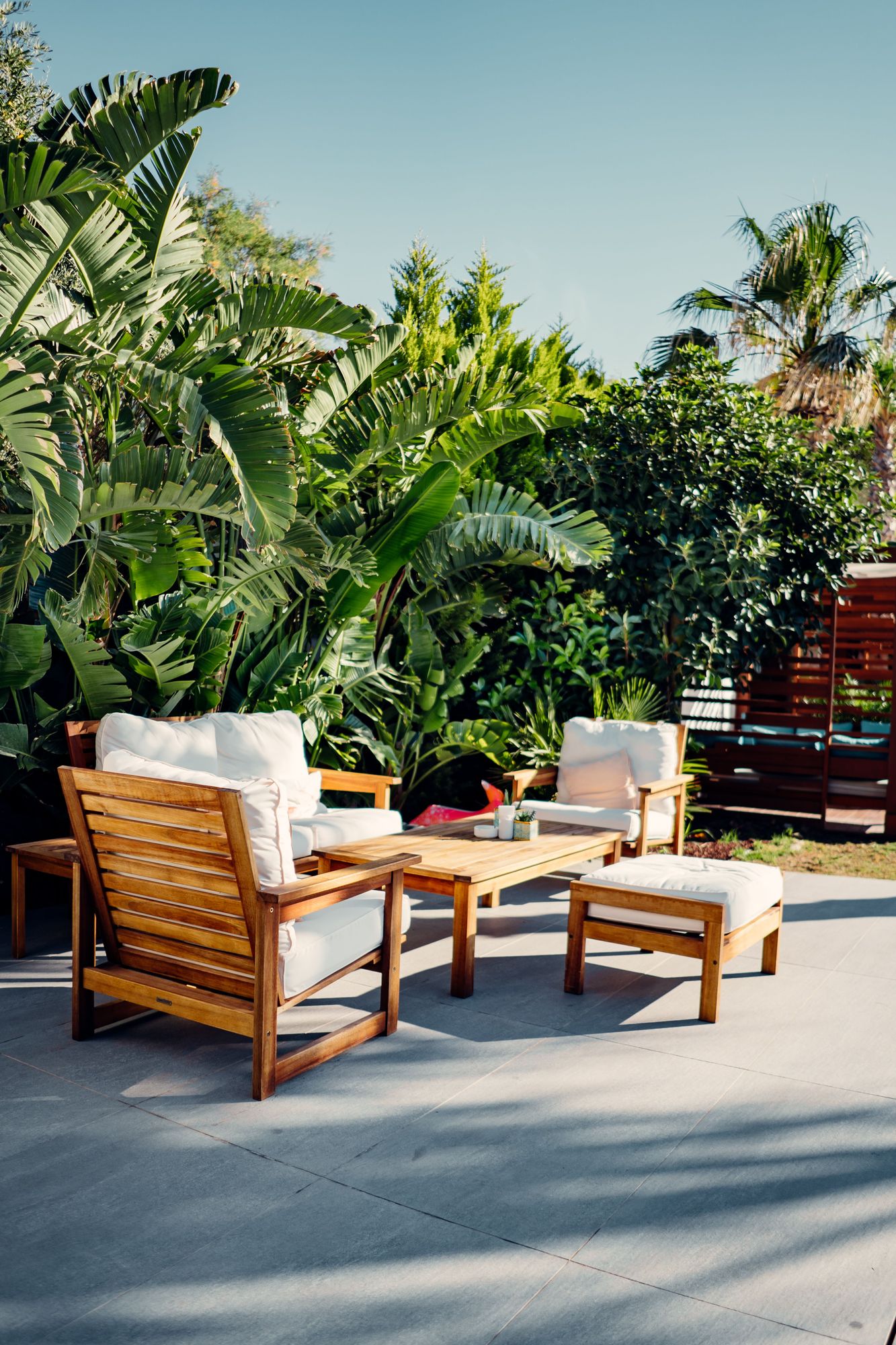 Teak outdoor sofa and armchairs in a tropical garden
