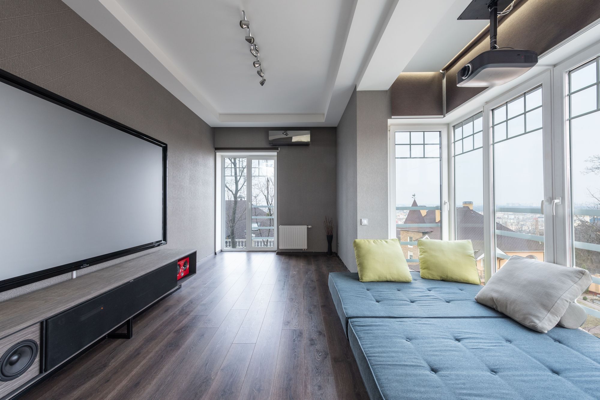 Media room with a wall-width projection screen and daybed seating