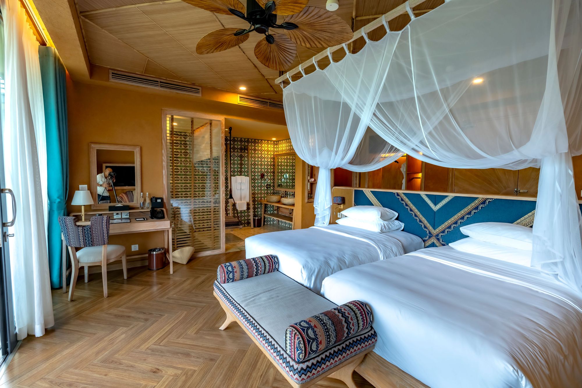 Twin-bed guest room with a mosquito-net canopy and woven textiles