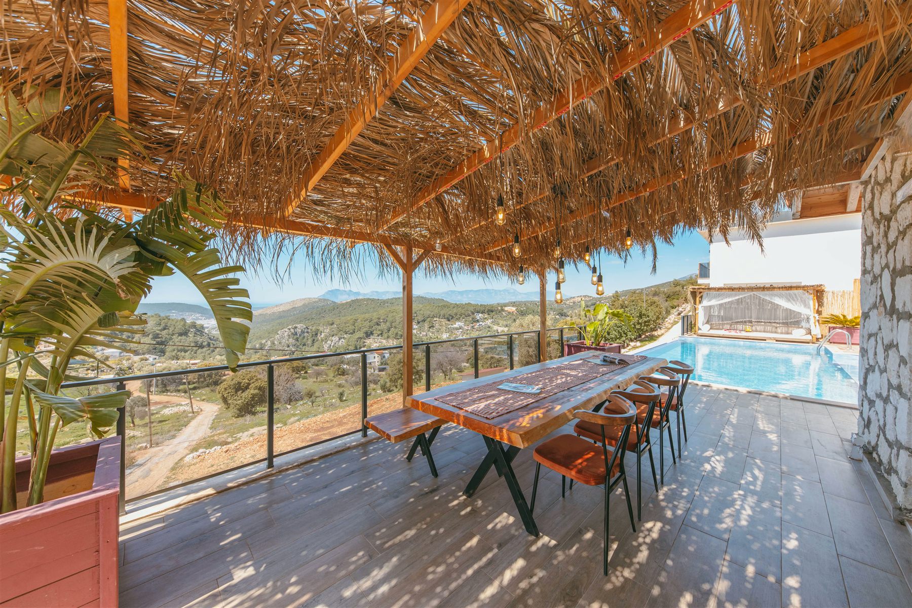 Live-edge table under a palapa on a pool terrace